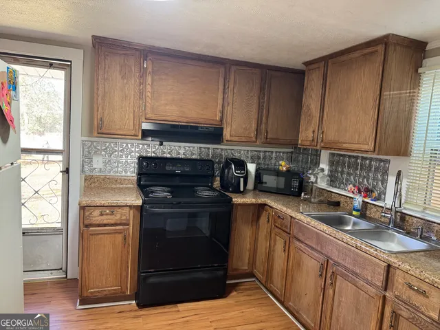 a kitchen with stainless steel appliances granite countertop a stove a sink and a refrigerator