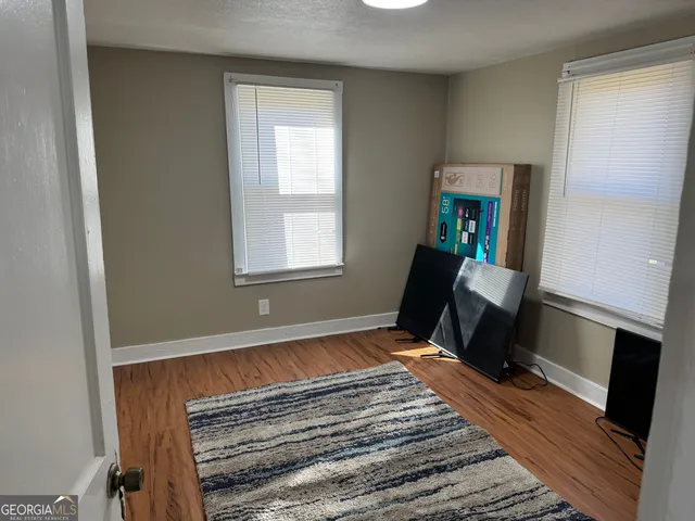 a view of a room with wooden floor and windows