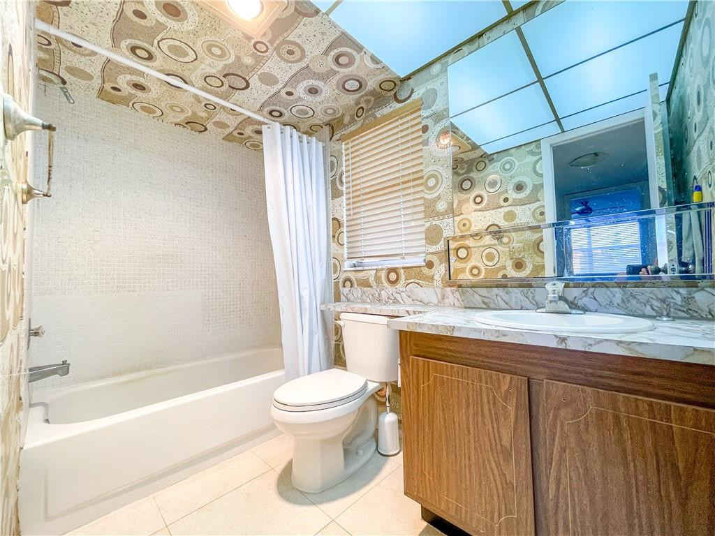 2781 North Pine Island Road, Unit 308 Sunrise, FL 33322 - Photo 15 of 16 a bathroom with a granite countertop sink toilet and shower