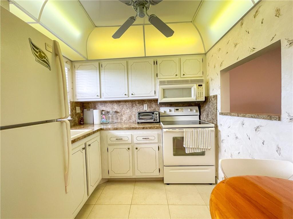 2781 North Pine Island Road, Unit 308 Sunrise, FL 33322 - Photo 6 of 16 a kitchen with stainless steel appliances white cabinets and a refrigerator