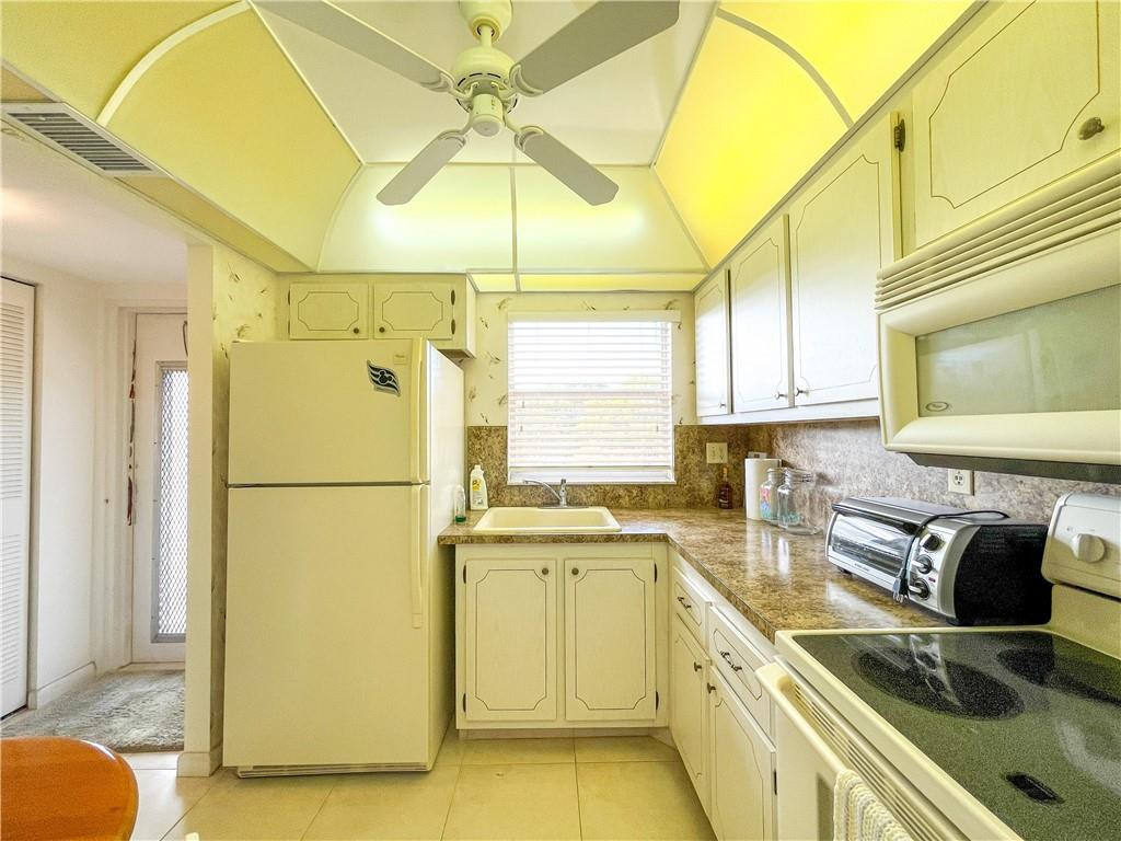 2781 North Pine Island Road, Unit 308 Sunrise, FL 33322 - Photo 7 of 16 a kitchen with a sink a refrigerator a stove and cabinets