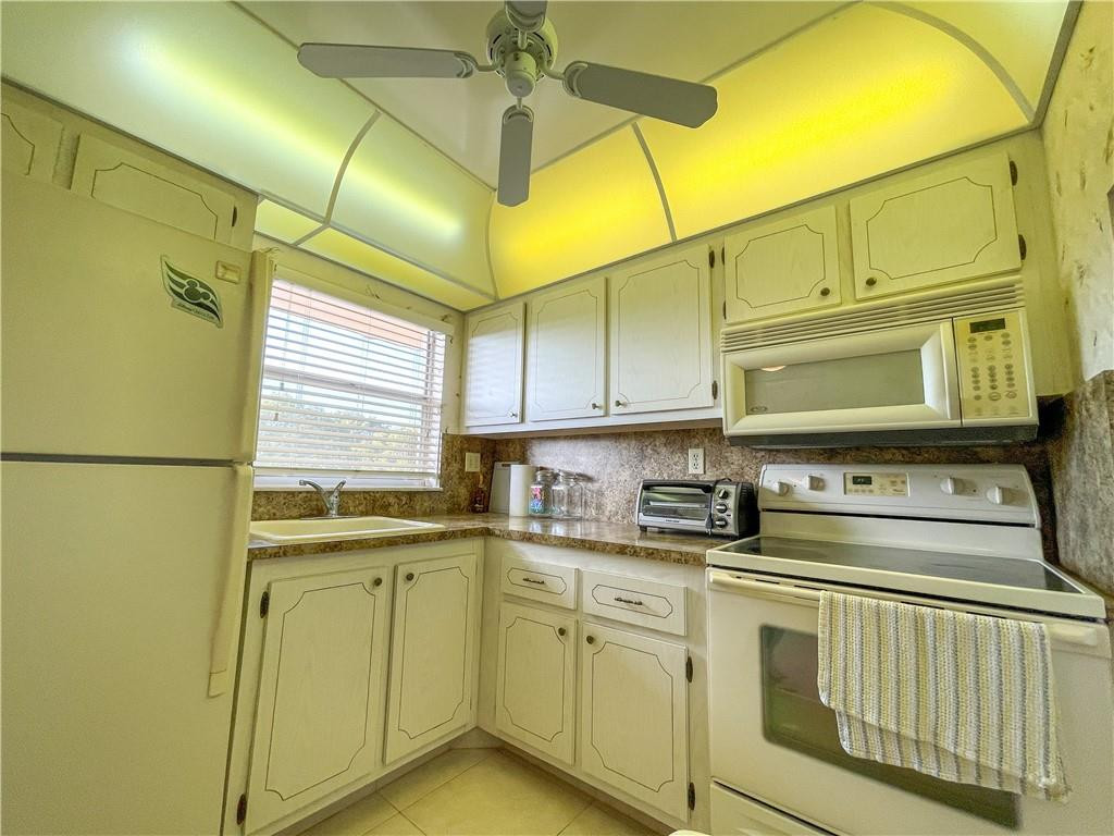 2781 North Pine Island Road, Unit 308 Sunrise, FL 33322 - Photo 8 of 16 a kitchen with stainless steel appliances white cabinets and a sink