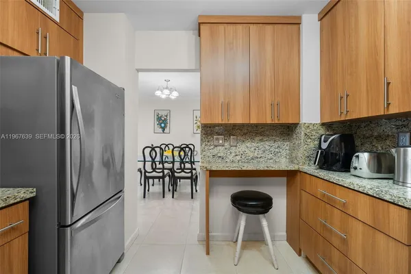 a kitchen with stainless steel appliances granite countertop a refrigerator and a stove top oven