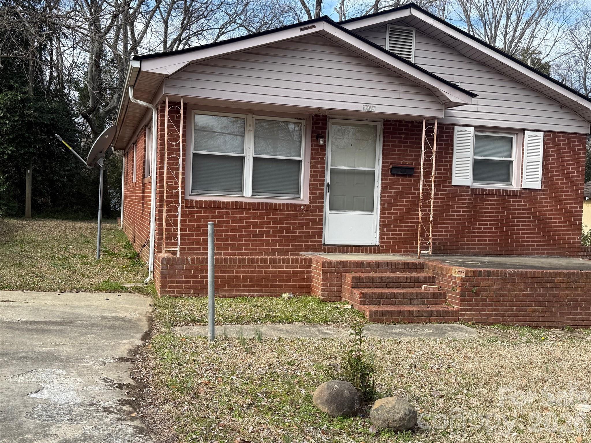 a front view of a house with plants