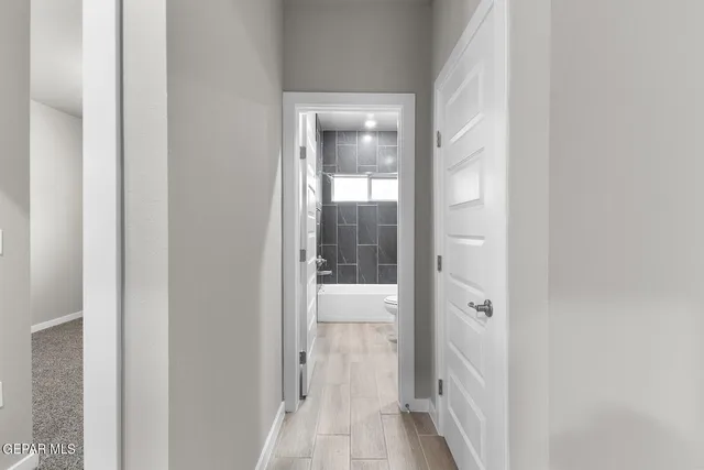 a view of a hallway with wooden floor