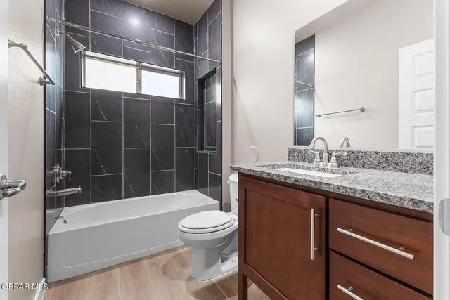 a bathroom with a granite countertop sink a toilet and a mirror