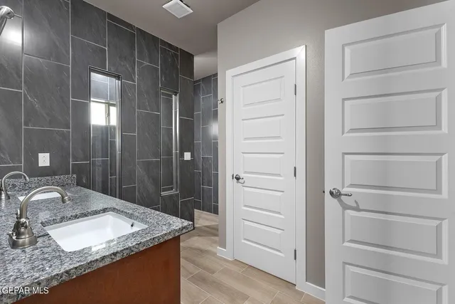 a bathroom with a granite countertop sink a shower and a mirror