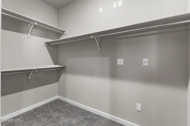 a view of walk in closet with empty racks