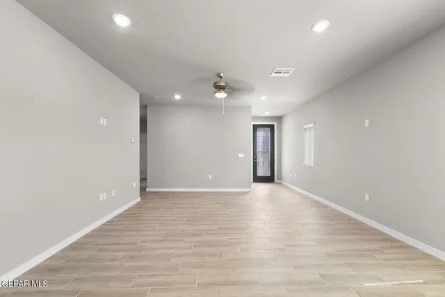 an empty room with wooden floor and a ceiling fan