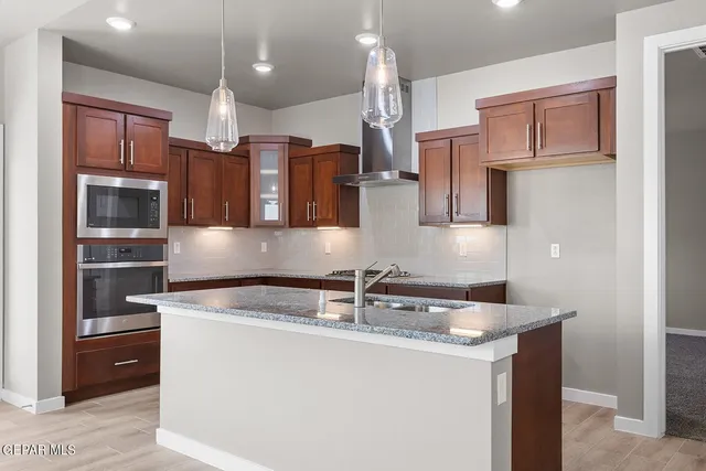 a kitchen with stainless steel appliances granite countertop a sink and a refrigerator