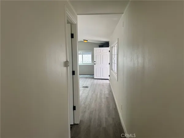 a view of a hallway with wooden floor