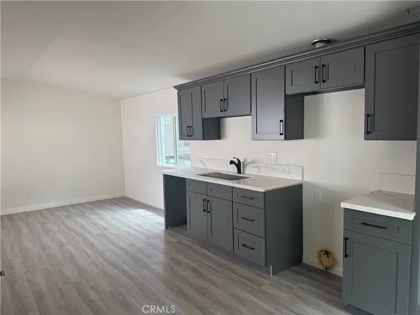a kitchen with sink cabinets and wooden floor
