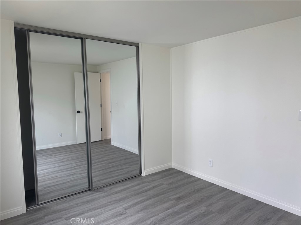 715 West 220th Street, Unit 47 Torrance, CA 90502 - Photo 10 of 15 an empty room with wooden floor and wooden door