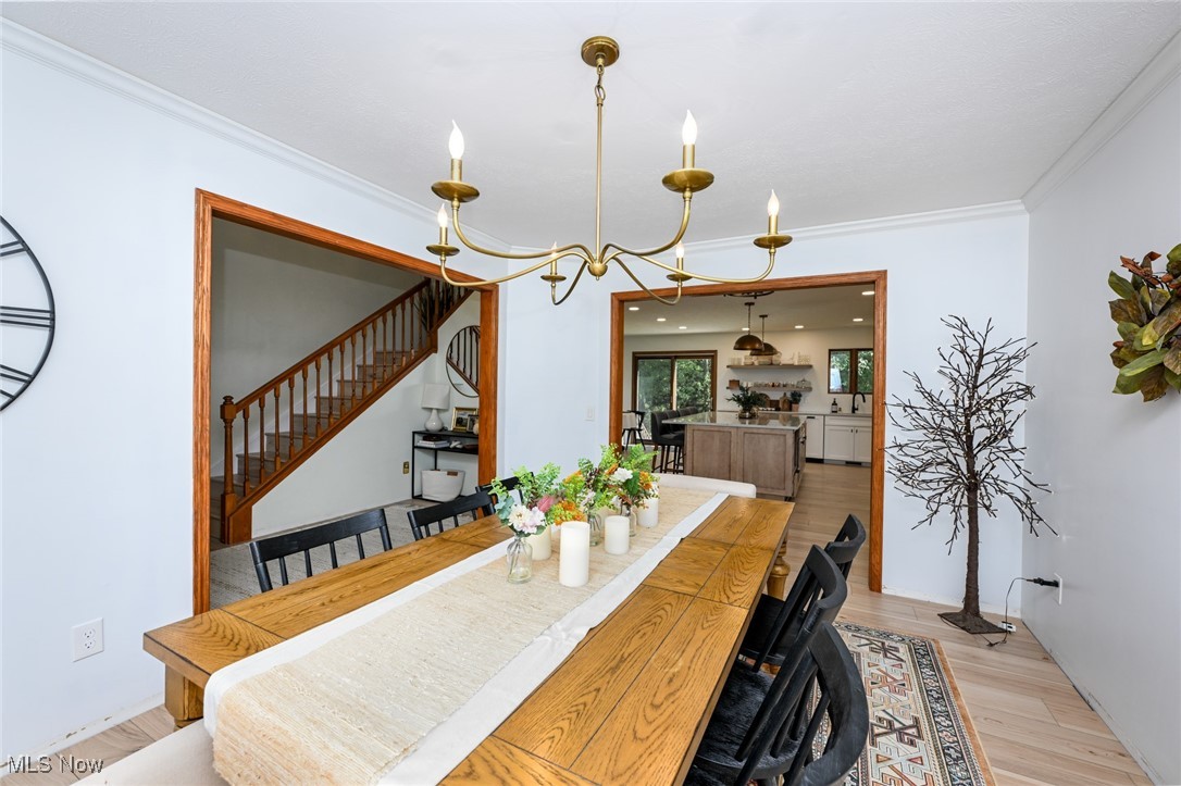 4845 State Road Medina, OH 44256 - Photo 13 of 47 Dining area featuring light wood finished floors, stairs, ornamental molding, and a chandelier