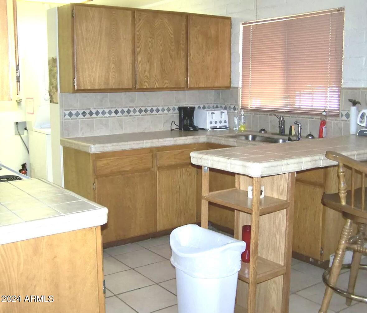 1240 Cedar Street Ajo, AZ 85321 - Photo 2 of 5 a bathroom with a sink a toilet and mirror
