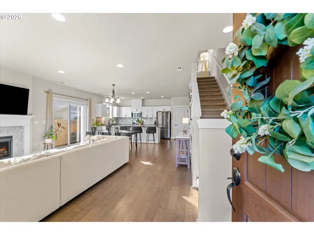 a living room with furniture a flat screen tv and a refrigerator