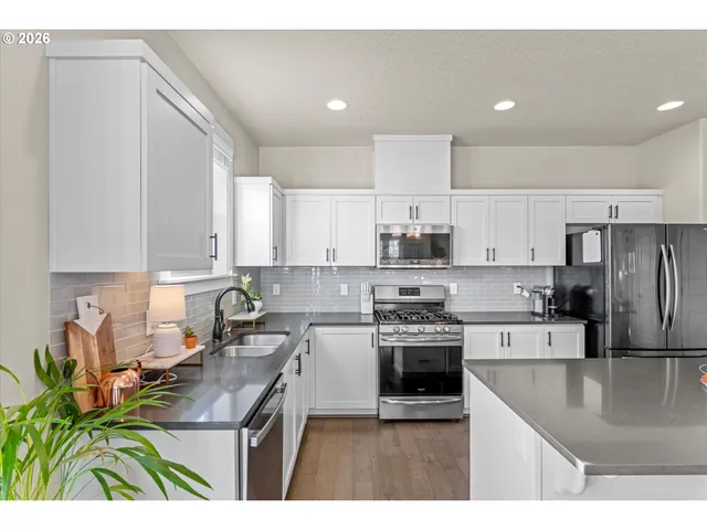 a kitchen with a dining table chairs and refrigerator