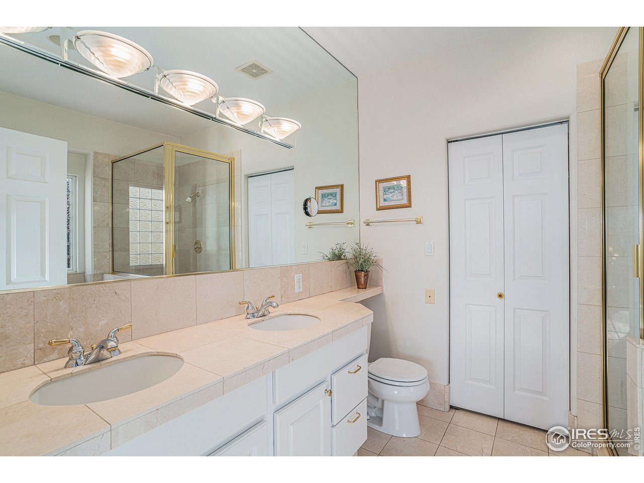 4402 30th Street Greeley, CO 80634 - Photo 16 of 31 a bathroom with a granite countertop sink a toilet and a mirror