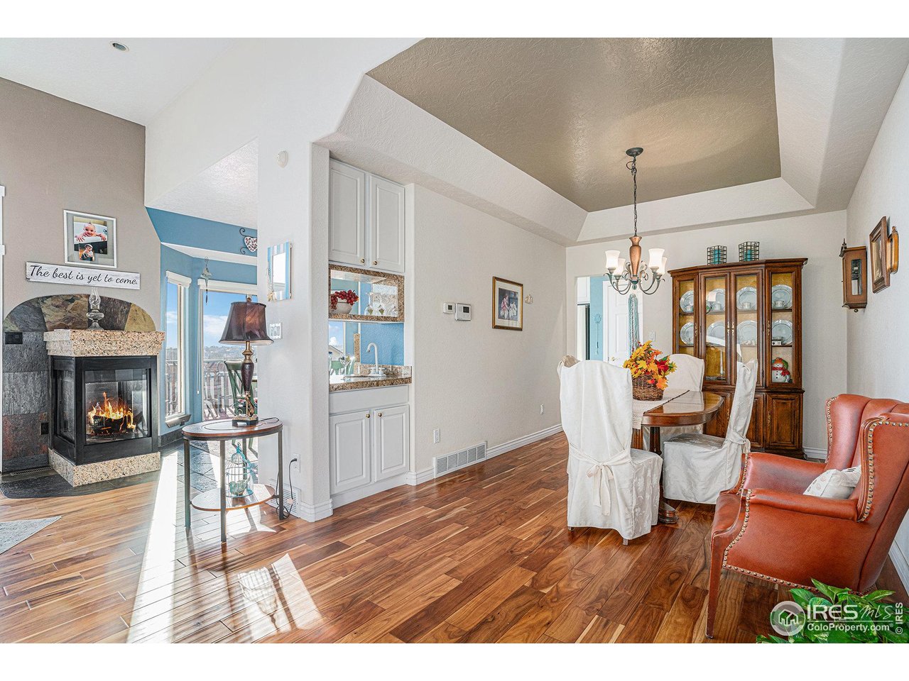 4402 30th Street Greeley, CO 80634 - Photo 7 of 31 a living room with furniture a fireplace and kitchen view