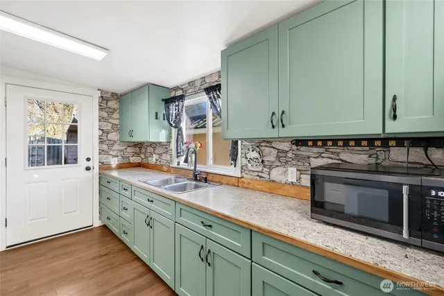 a kitchen with stainless steel appliances granite countertop a sink a stove and a microwave oven