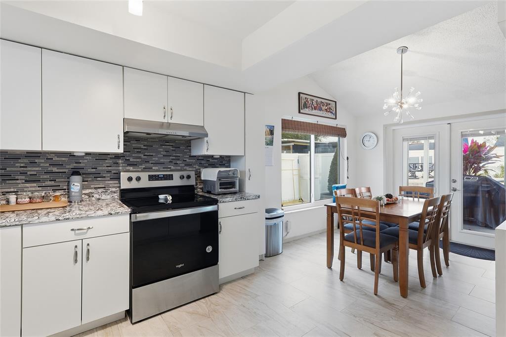 9084 Arndale Circle Tampa, FL 33615 - Photo 9 of 22 a kitchen with a stove a table and chairs in it