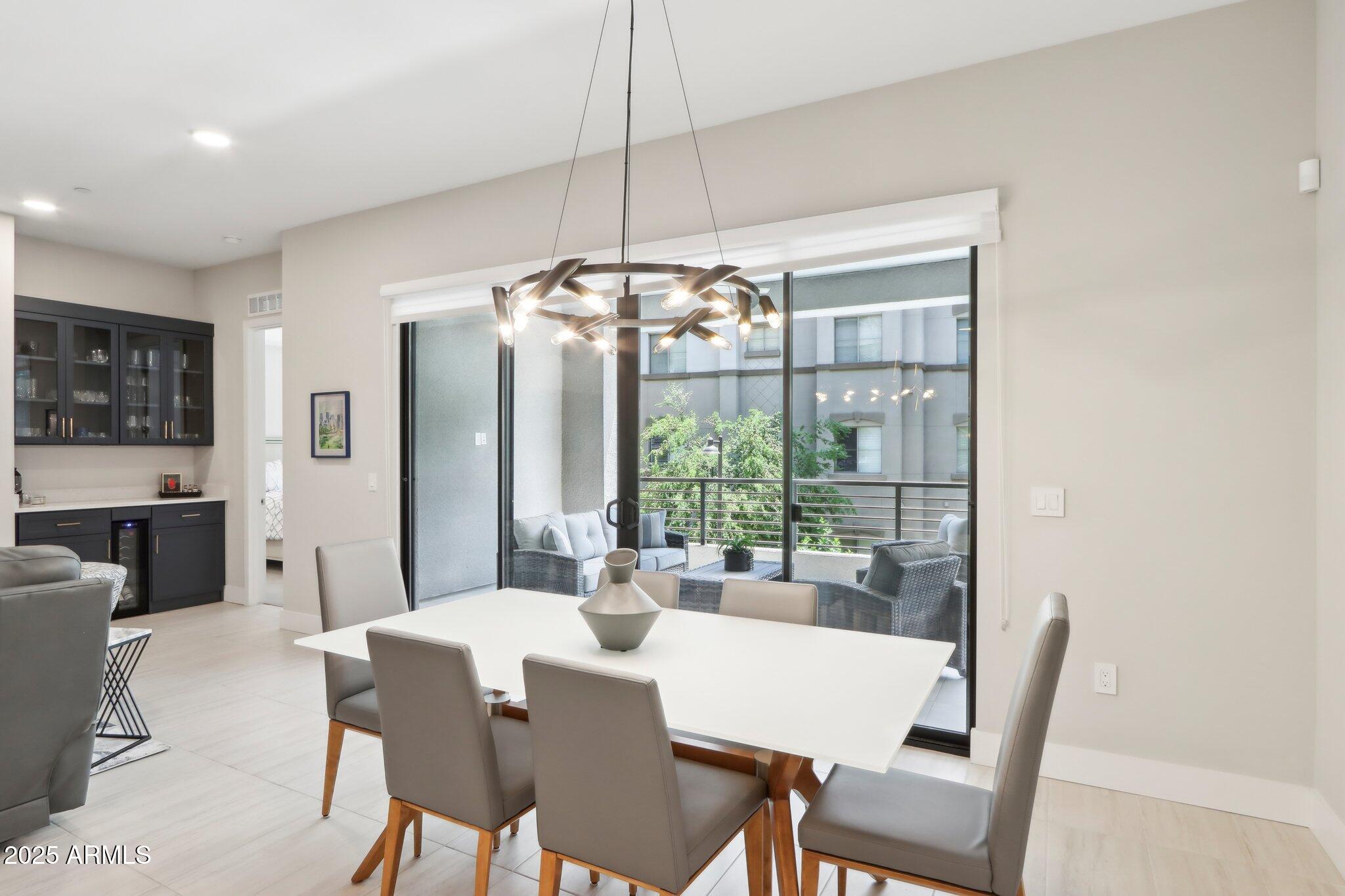 5250 East Deer Valley Drive, Unit 247 Phoenix, AZ 85054 - Photo 11 of 56 a view of a dining room with furniture wooden floor and chandelier