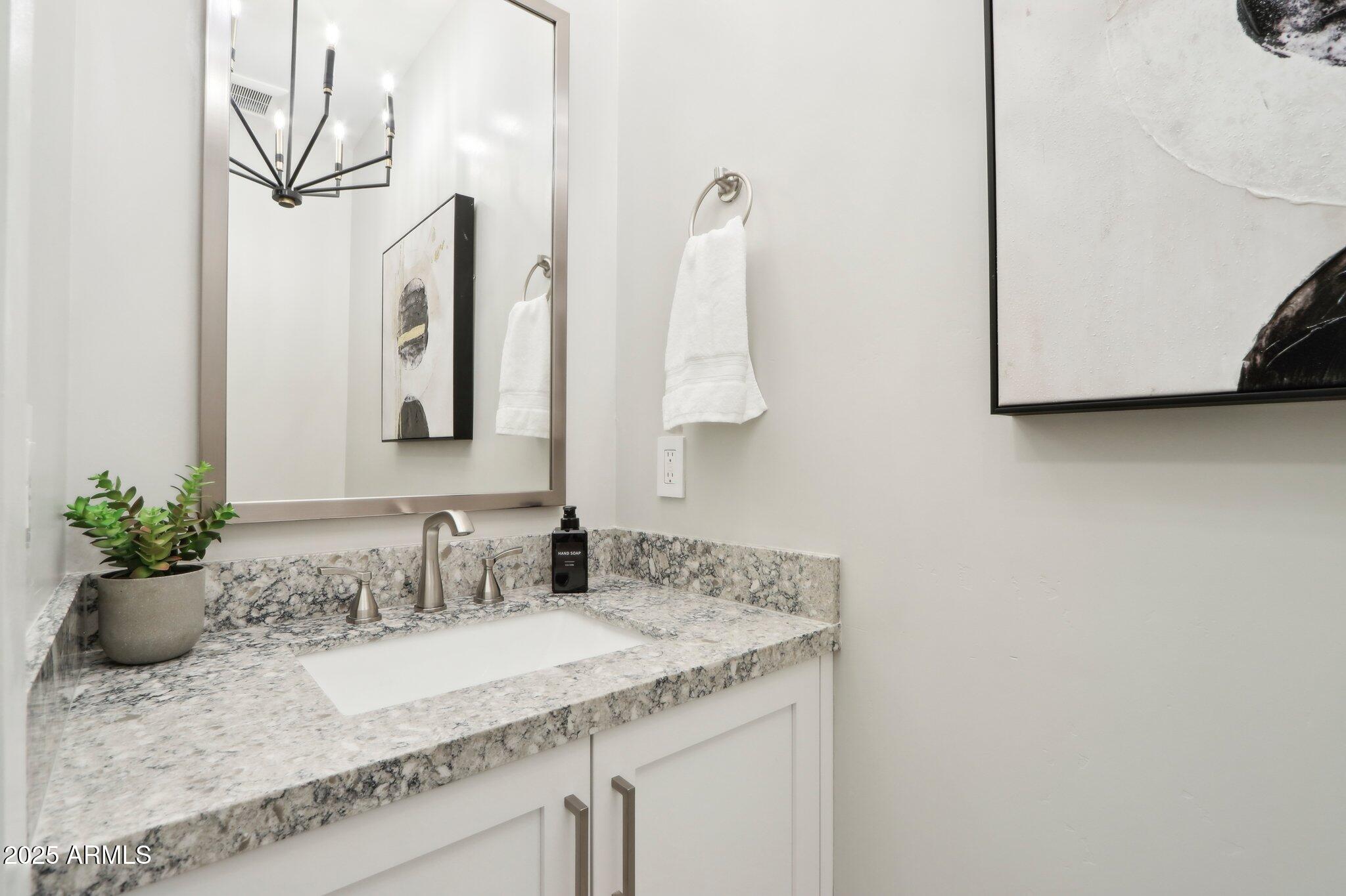 5250 East Deer Valley Drive, Unit 247 Phoenix, AZ 85054 - Photo 13 of 56 a bathroom with a granite countertop sink and a mirror
