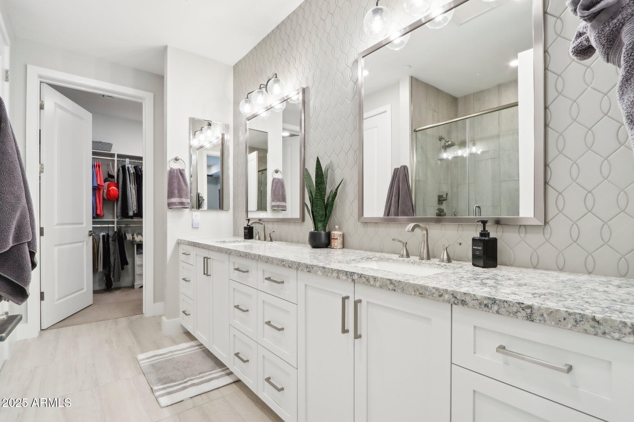 5250 East Deer Valley Drive, Unit 247 Phoenix, AZ 85054 - Photo 17 of 56 a bathroom with a granite countertop double vanity sink and mirror
