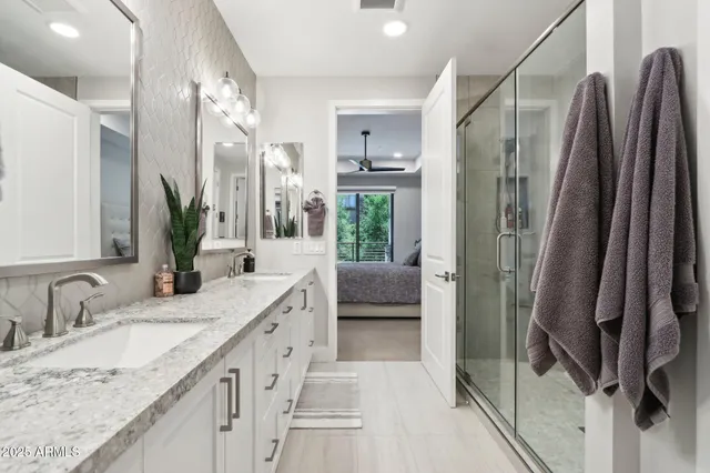 a bathroom with a granite countertop double vanity sink and mirror