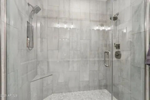 a bathroom with a granite countertop sink a mirror and a shower