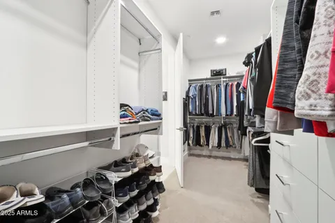 a view of walk in closet with clothes and shoes