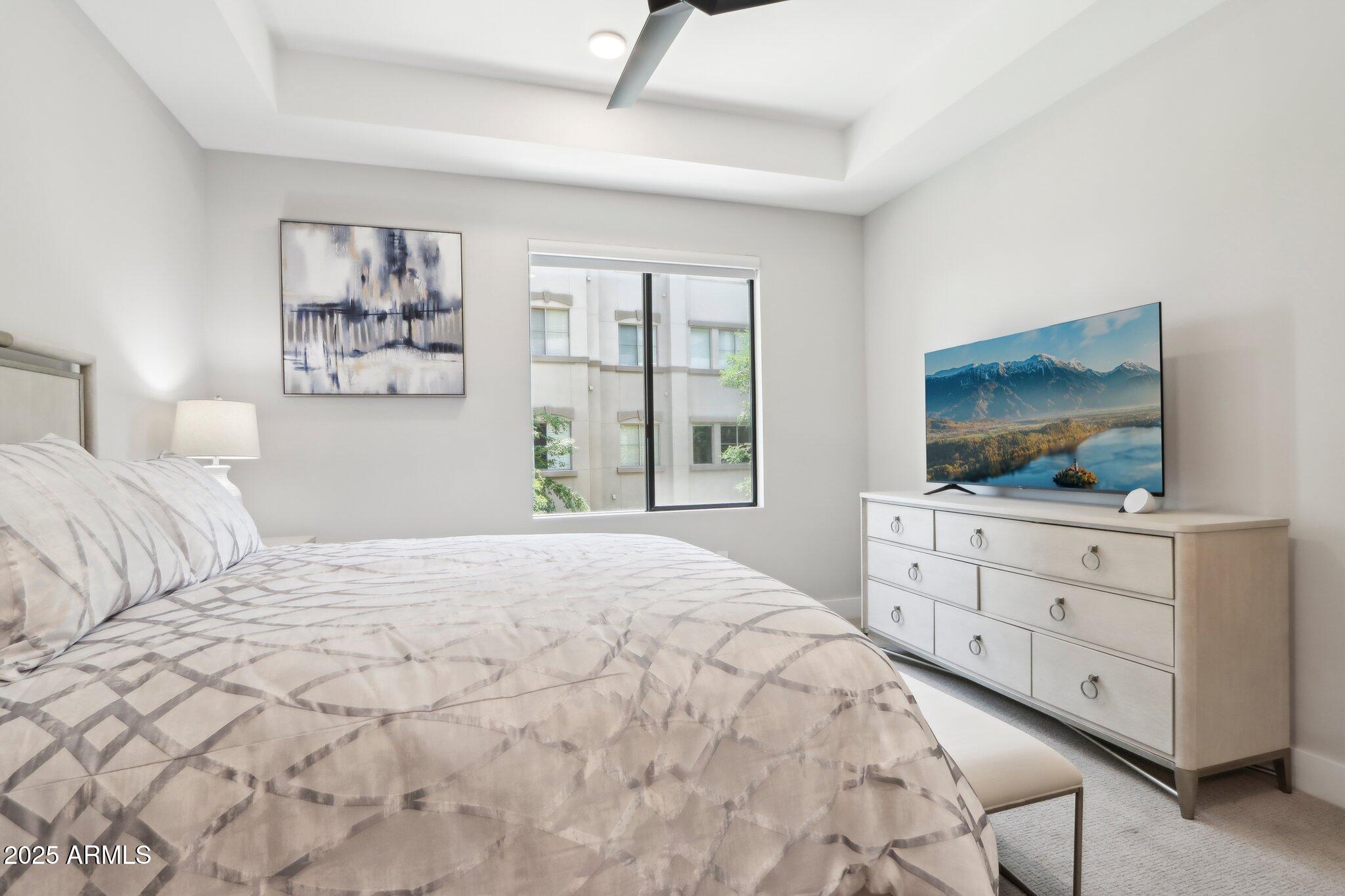 5250 East Deer Valley Drive, Unit 247 Phoenix, AZ 85054 - Photo 22 of 56 a bedroom with a large bed and a flat screen tv