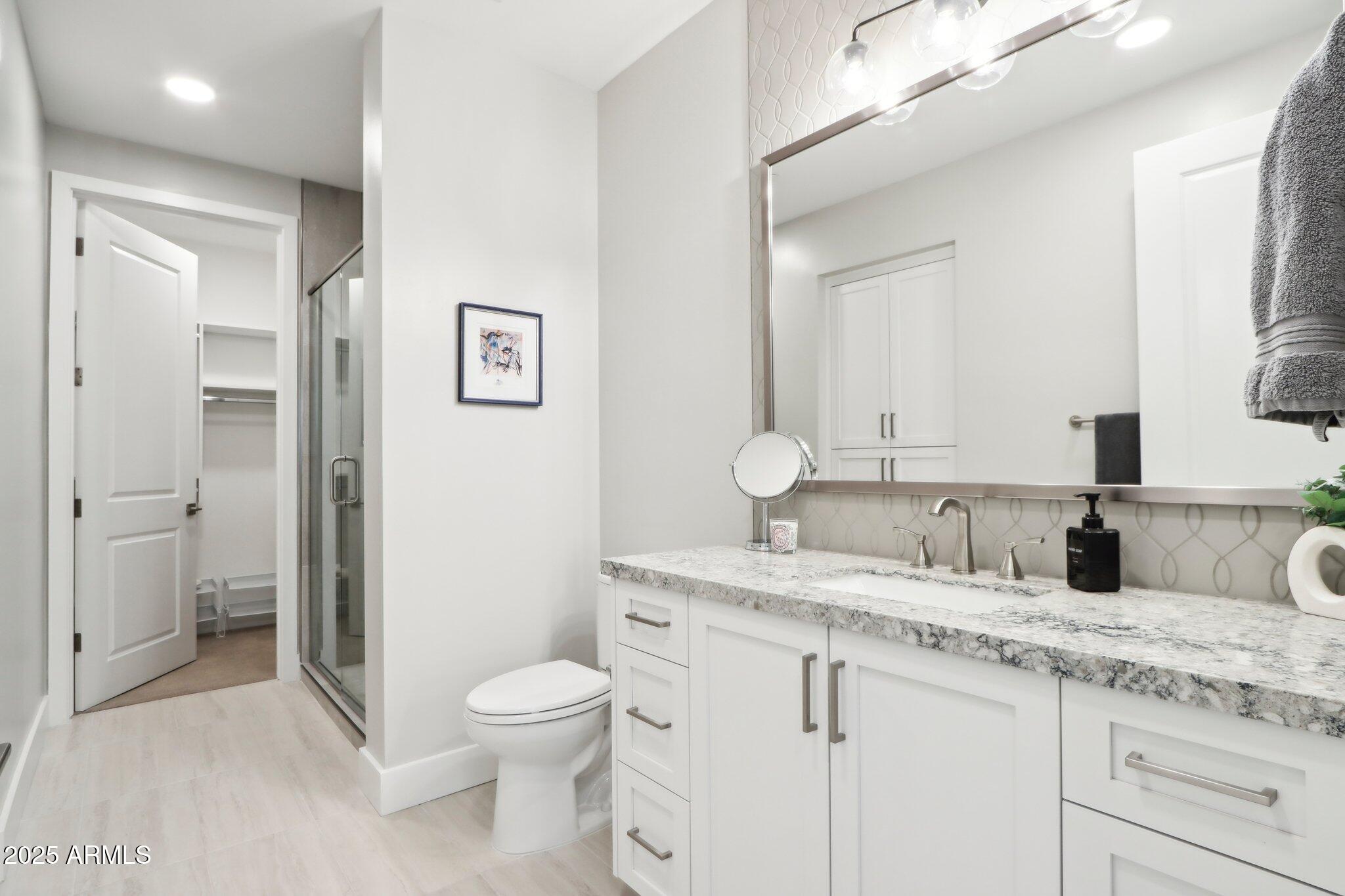 5250 East Deer Valley Drive, Unit 247 Phoenix, AZ 85054 - Photo 23 of 56 a bathroom with a granite countertop toilet sink and a mirror