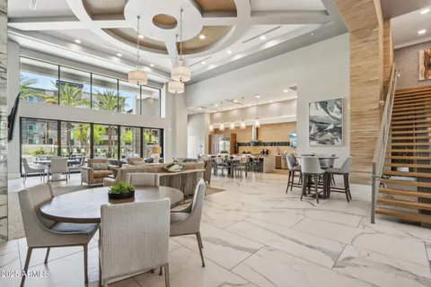 a living room with furniture a large window and wooden floor