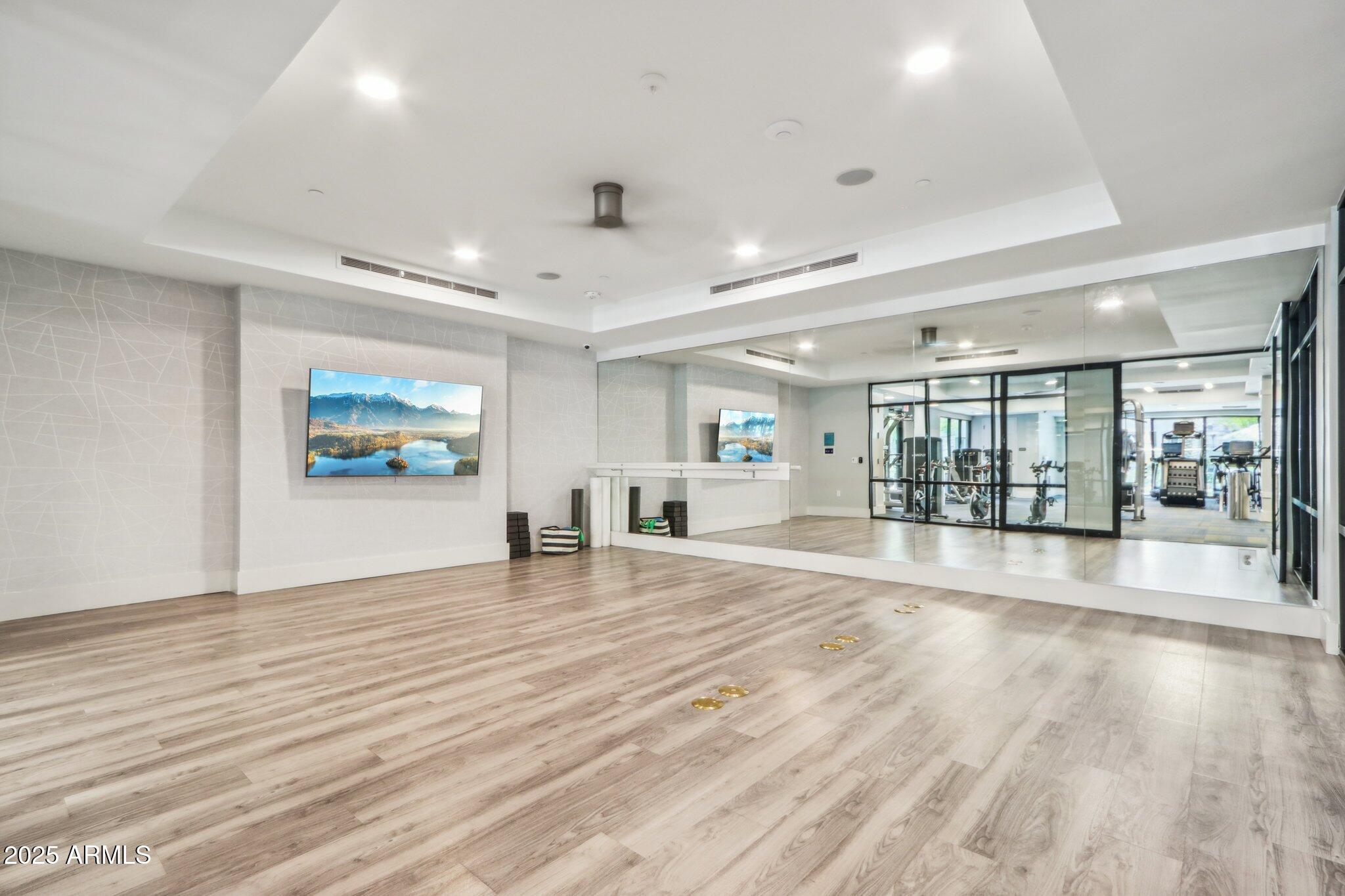 5250 East Deer Valley Drive, Unit 247 Phoenix, AZ 85054 - Photo 39 of 56 an empty room with wooden floor and windows