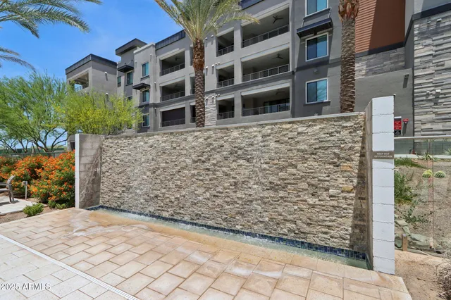 a view of a swimming pool with lawn chairs under an umbrella