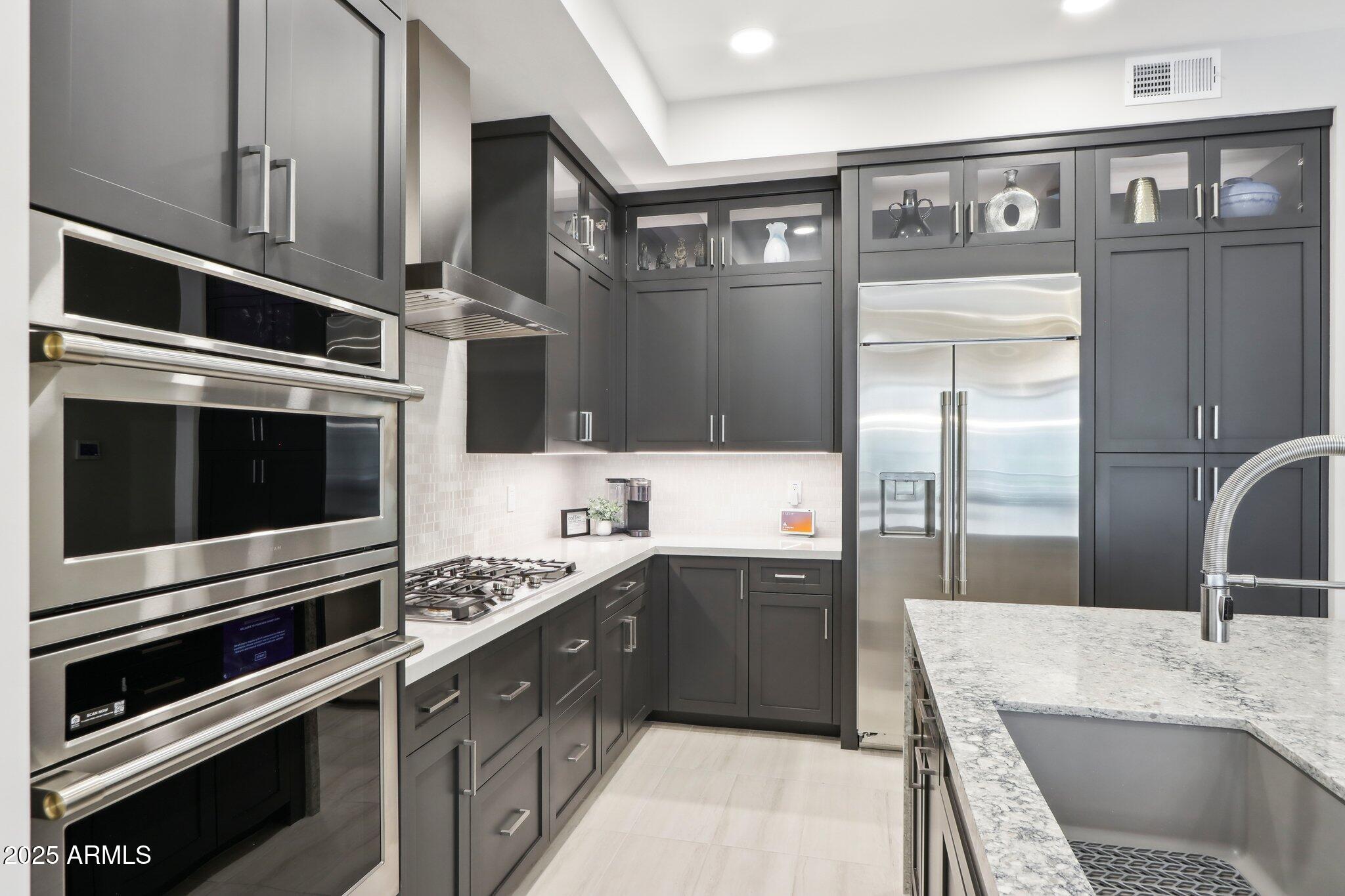 5250 East Deer Valley Drive, Unit 247 Phoenix, AZ 85054 - Photo 4 of 56 a kitchen with stainless steel appliances kitchen island granite countertop a sink stove and refrigerator
