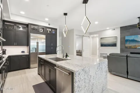 a kitchen with stainless steel appliances kitchen island granite countertop a sink stove and refrigerator