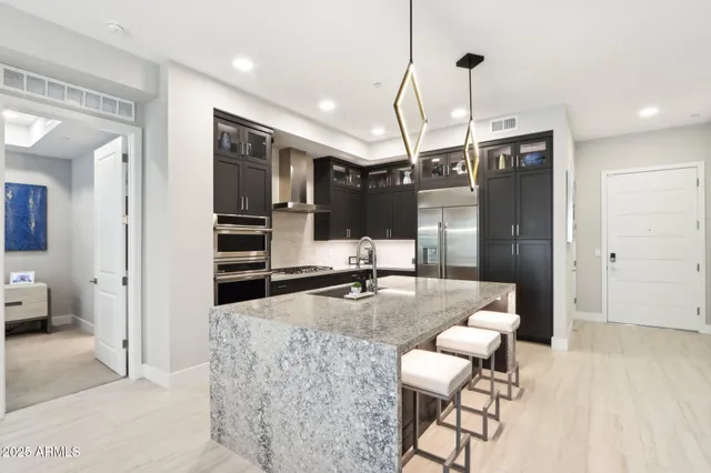 a living room with furniture kitchen view and a large window