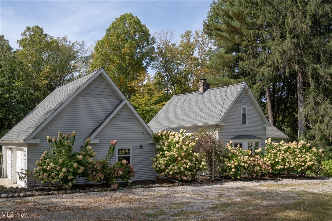 8145 Chagrin Road Chagrin Falls, OH 44023 - Photo 2 of 40 View of home's exterior with roof with shingles, a chimney, and view of wooded area