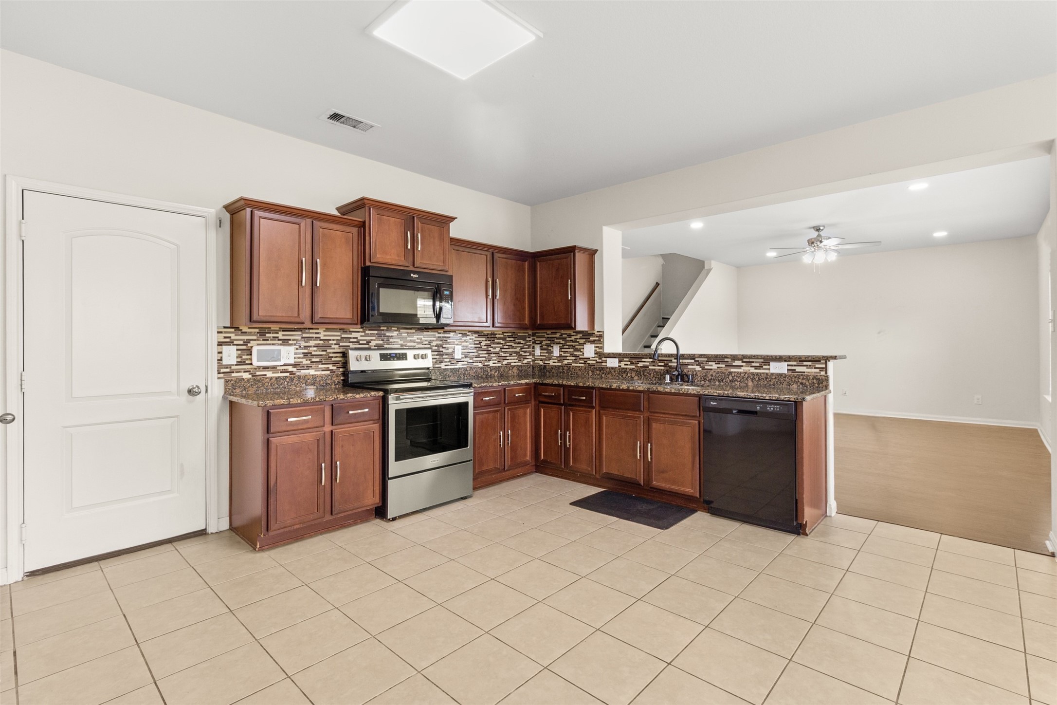 9426 Grand Spark Drive Rosharon, TX 77583 - Photo 7 of 31 The heart of the home, this well-appointed kitchen combines style and functionality with abundant cabinetry and expansive countertop space. The beautiful backsplash adds visual interest while complementing the warm cabinetry tones.