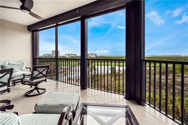 a living room with fireplace furniture chandelier and a large window