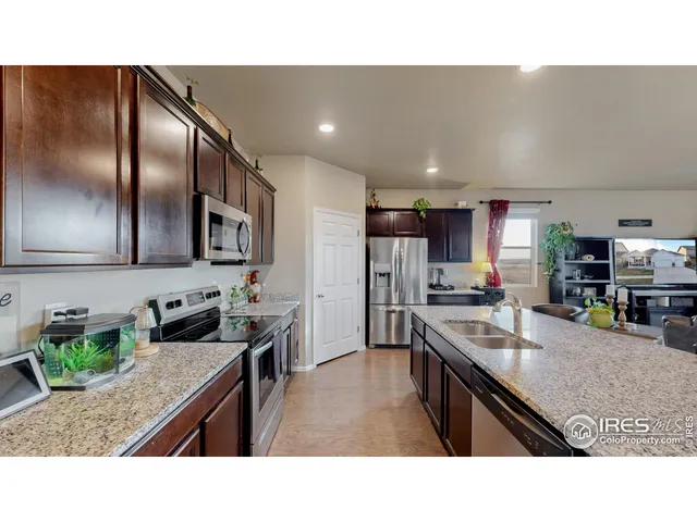 a kitchen with stainless steel appliances granite countertop a sink dishwasher stove top oven and refrigerator