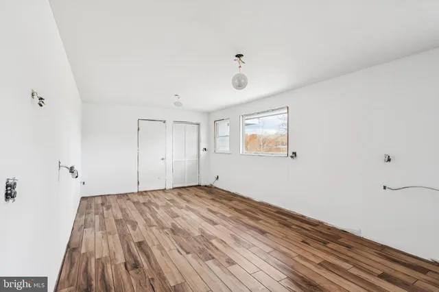 a view of a room with wooden floor and windows