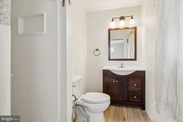 a bathroom with a toilet a sink and mirror