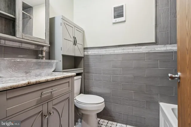 a bathroom with a granite countertop toilet sink and mirror