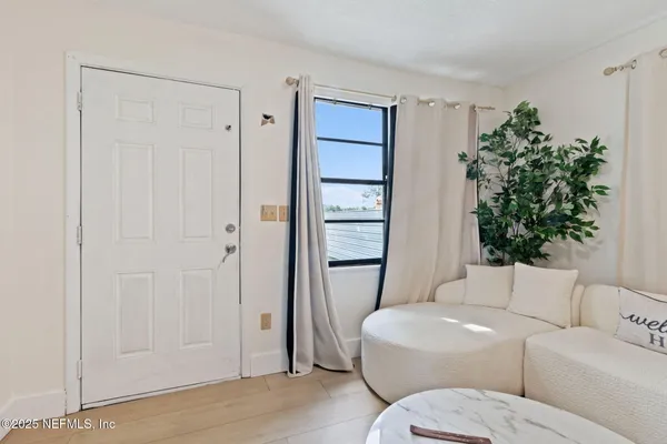 a living room with furniture a potted plant and a toilet