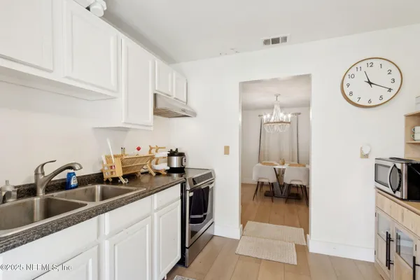 a kitchen with a sink a stove and cabinets