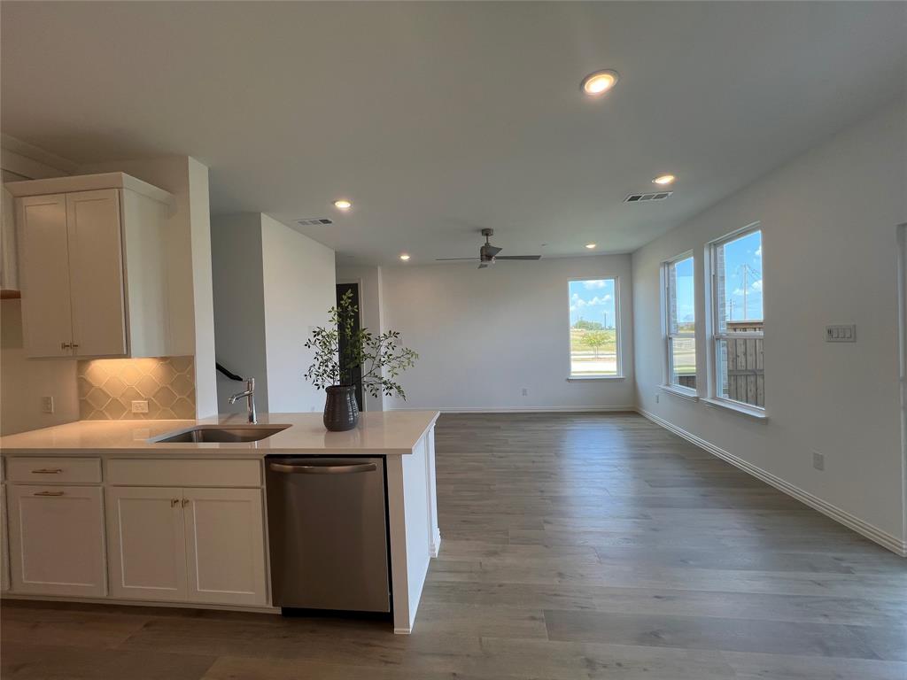 2616 Rolling Mdw Road Celina, TX 75009 - Photo 11 of 35 Kitchen with white cabinets, stainless steel dishwasher, recessed lighting, light wood-type flooring, and decorative backsplash