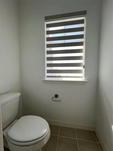 a white toilet sitting next to a window